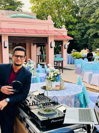 Here I am at my console, ready to spin for a big fat wedding at The Leela Palace Bengaluru. The setup is against the backdrop of the beautiful outdoor decor, showing how I integrate seamlessly into your event.