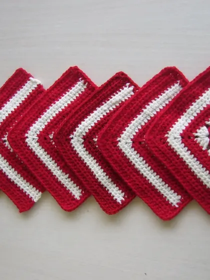 A set of red and white coasters, some with a solid center and some with the classic granny square pattern. They make a lovely, coordinated set.
