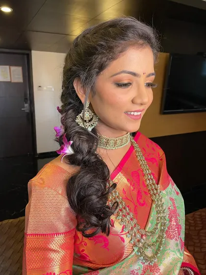 A side profile showing the beautiful texture of the braid and the intricate details of her traditional earrings.
