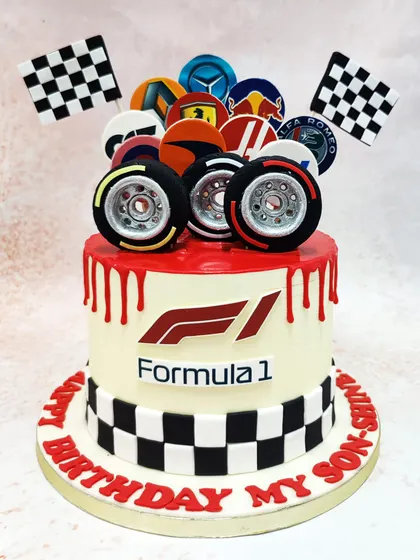 We bring the thrill of the race to your party with this high-octane Formula 1 cake. Featuring the F1 logo, checkered flags, edible tires, and the logos of top racing teams, this cake is a guaranteed winner for any motorsport enthusiast.