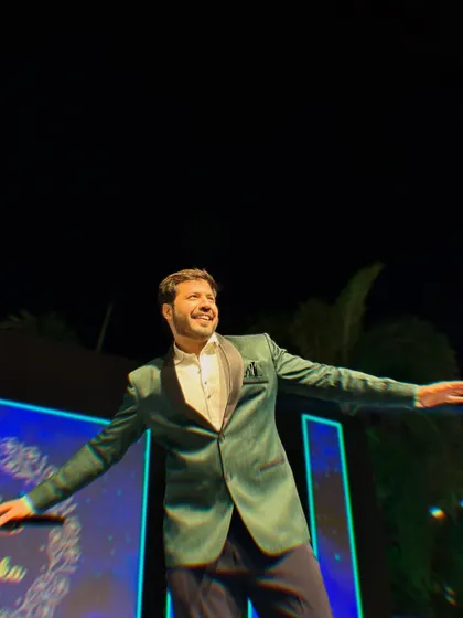 In full Shah Rukh Khan pose on stage, embracing the grandness of the Sangeet night.