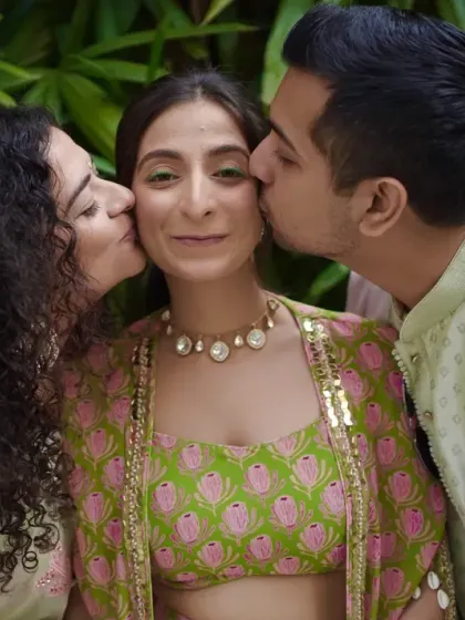The bride being showered with kisses from her siblings, a testament to the close family bonds.