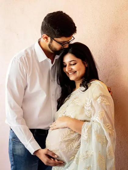 A tender kiss for the mama-to-be. This indoor couple portrait is so gentle and loving, showing the support and affection between partners during this special time.