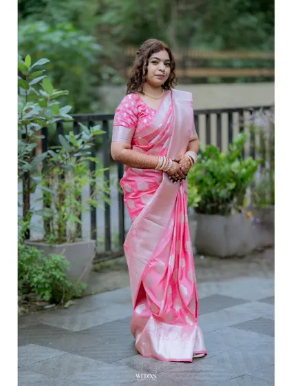 A full-length shot of the bride in her pink saree, providing a complete view of her elegant look for the occasion.