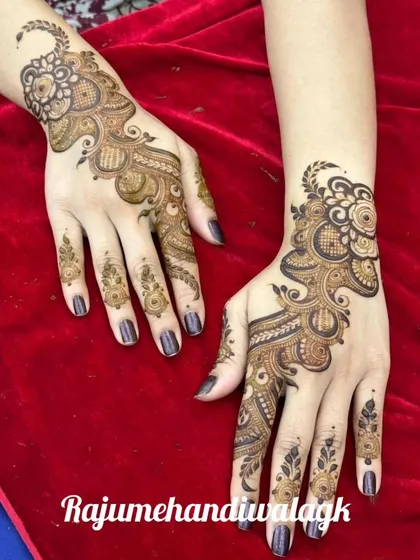 This Arabic-style mehandi design flows diagonally across the back of the hand. It combines floral and paisley elements and is a very popular and elegant choice for guests.
