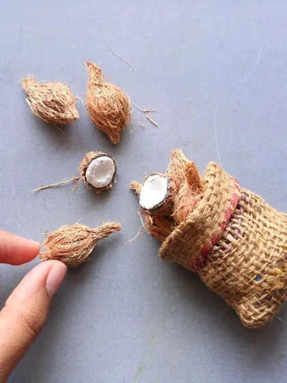 A close-up of a miniature sack of coconuts, showing the detailed texture.