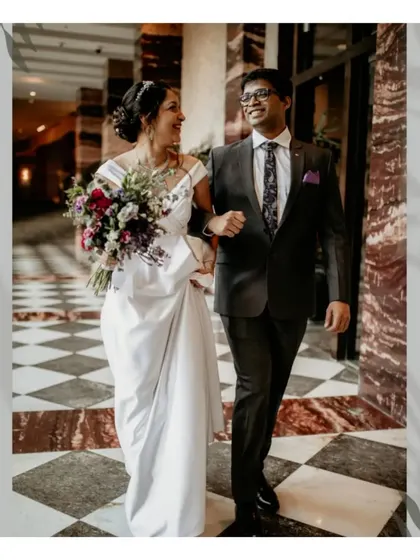 A happy, candid shot of a Christian bride and groom walking together after their ceremony.
