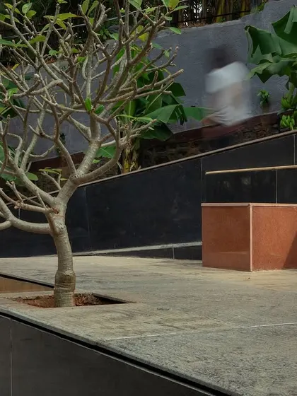 **Nepean Greens, Mumbai:** A sneak peek of the plaza's multi-level terraces and seating areas. The design provides a variety of spaces, from open platforms for groups to quieter corners for individuals, all surrounded by lush greenery.