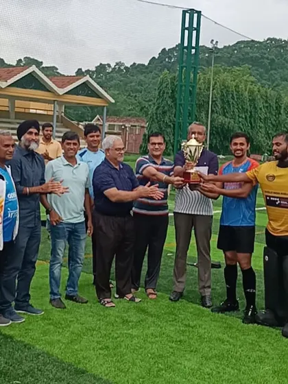 The team and officials gather to receive the winners' trophy for the Anushaktinagar Monsoon Hockey Tournament. It takes a whole community to achieve victory.