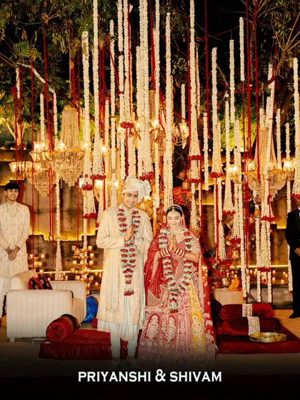 The newlyweds, Priyanshi and Shivam, share their first moments as a married couple. They stand under a breathtaking mandap of cascading flowers and chandeliers, a perfect start to their journey.
