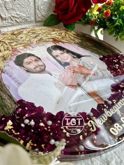 A close-up view shows the different textures of the preserved engagement flowers, from the delicate red petals to the stalks of wheat, all sealed in clear resin.