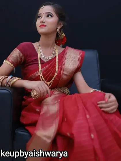This portrait captures the grace of a bride in her red wedding saree. The complete styling, including the makeup, hair, and saree draping, comes together to create a truly memorable look.