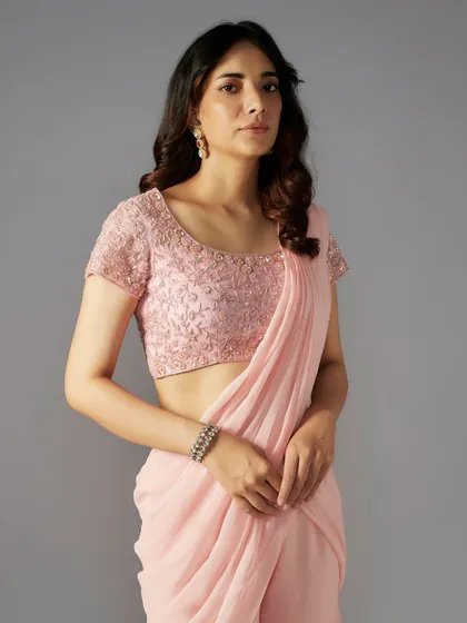 A closer look at the embellished blouse of the pink sharara-saree, featuring delicate floral embroidery.