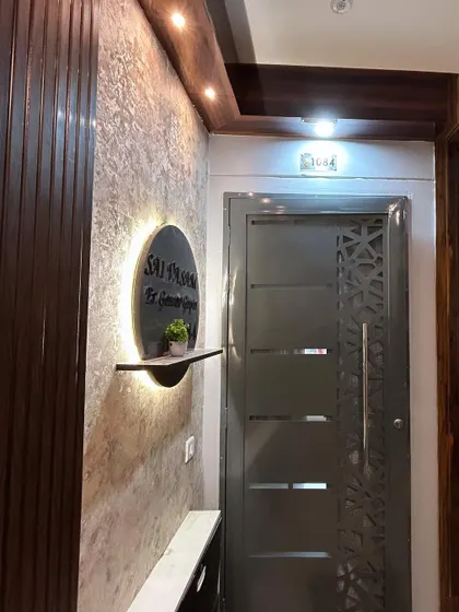 A close-up of the entrance, highlighting the details of the backlit nameplate and the rich textures of the wall panels.