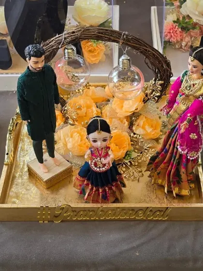 A complete custom family doll set on a decorative tray. This piece was created for an engagement, capturing the couple and their child in a beautiful arrangement.