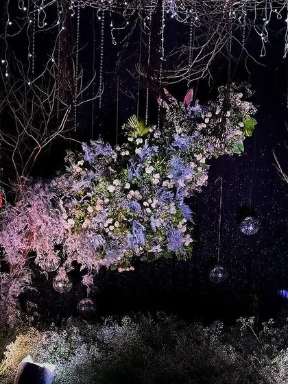 A detailed shot of the central floral installation in our enchanted forest theme. We used a mix of white and pale purple flowers, surrounded by delicate branches, to create a piece that appears to float in mid-air.