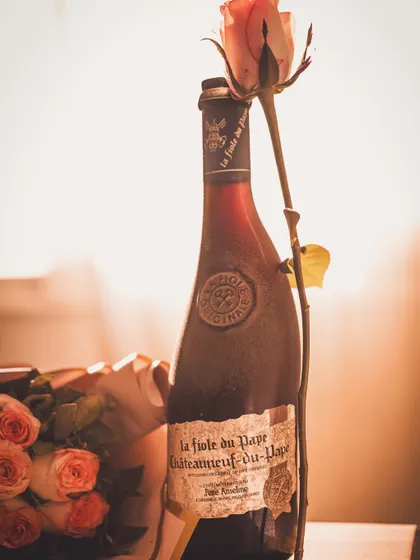 A backlit shot of the vintage wine bottle, creating a warm, golden glow that enhances its classic appeal.