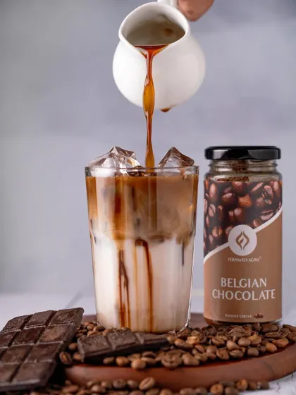 A rich espresso shot being poured into a glass of milk for a Belgian Chocolate iced coffee. The contrast between the dark coffee and the white milk creates a visually stunning moment.