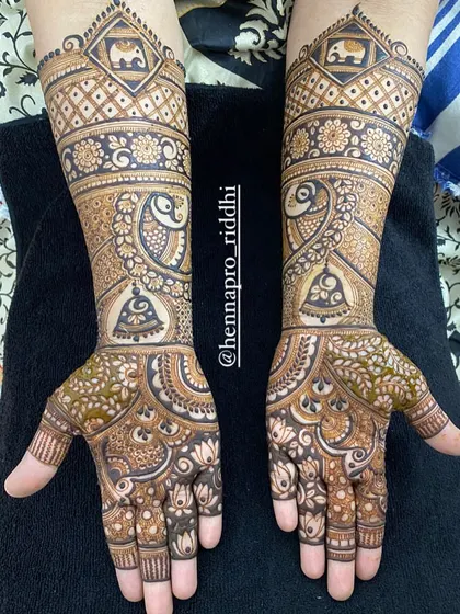An elbow-length design perfect for a semi-bridal look or for wedding guests. It's filled with beautiful traditional elements like peacocks, elephants, and bells, offering an intricate yet lighter feel.