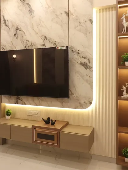 This TV unit in a Bhayandar home combines a marble-finish back panel with fluted wood and integrated shelving. The curved LED strip lighting adds a soft, ambient glow and highlights the different textures used in the design.