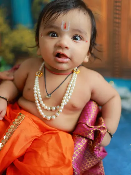 A close-up portrait that highlights the sweet, chubby cheeks and innocent expression of this baby Krishna. These are the details you'll want to remember forever.