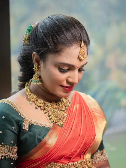 A close up of the traditional baby shower makeup for Archana. You can see the detail in the eye makeup and how the gold jewelry is perfectly balanced with the warm tones on her skin.