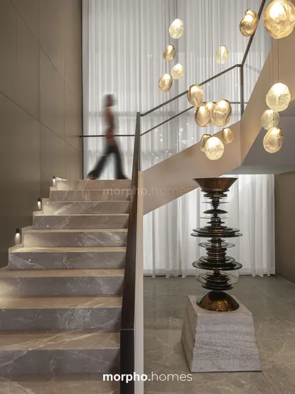 I conceived this staircase in a private residence as more than a vertical connector; it is a sculptural pause within the home. Clad in honed stone with integrated lighting, it rises alongside a cascade of pendant lights, transforming a functional element into an experience of light, material, and art.