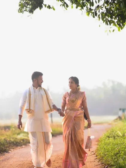 Capturing the couple walking hand-in-hand on a country road. The warm sunlight gives this pre-wedding photograph a soft, dreamy quality.