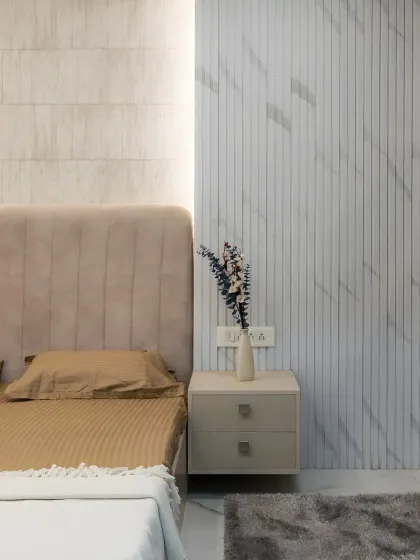 This image showcases the beautiful combination of textures in the bedroom, with a soft upholstered headboard placed next to a wall with sleek, marble-finish fluted panels.