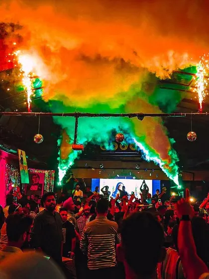 A full blast of color and effects. This shot captures the vibrant chaos of a peak-time party with colored smoke and sparklers.