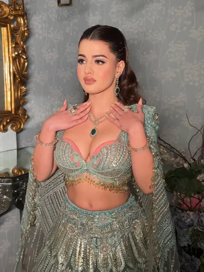 The full ensemble, where the makeup perfectly complements the pastel blue and pink tones of the lehenga. The scattered rhinestones on the face echo the outfit's sparkle, creating a cohesive and heavenly look.