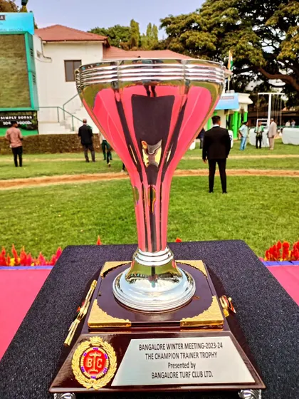 The Champion Trainer Trophy, a tall and elegant silver cup.