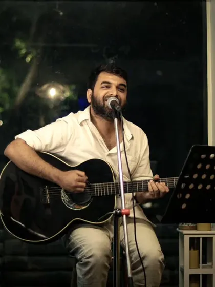 An artist sharing his music and stories with the audience. The simple, clean setup allows the performer's talent to be the main focus of the evening.
