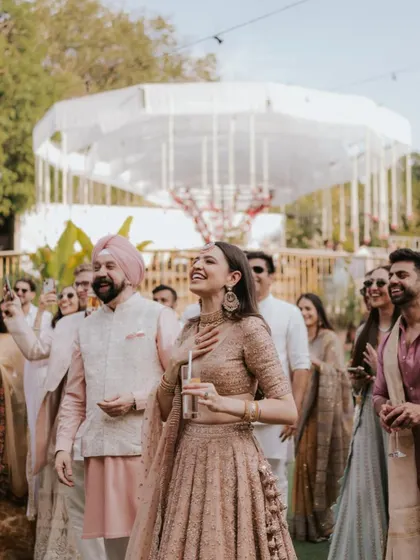 A candid shot of the bride enjoying a moment of laughter and joy with her family and friends.
