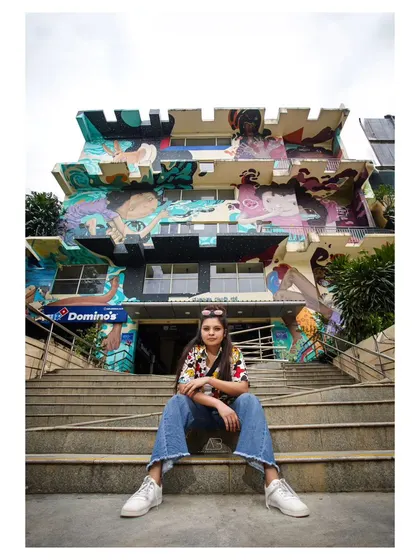 A wider shot of the same urban location, using the steps and the mural-covered building to create a sense of scale and environment.