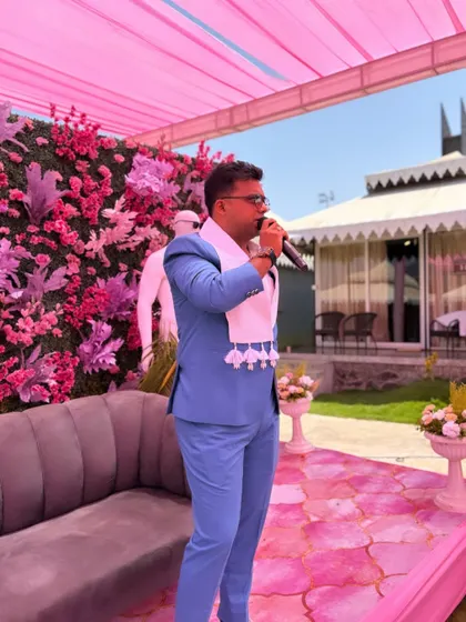 On stage in my blue suit, addressing the guests at an outdoor event. The look is professional yet stylish, perfect for a destination wedding.
