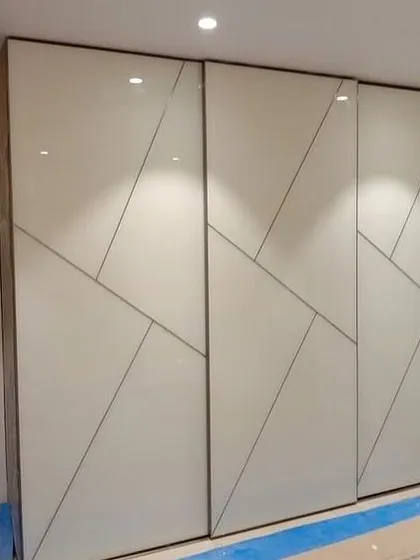 These sliding wardrobe doors feature a striking geometric pattern that adds a dynamic and modern element to the bedroom. The glossy white finish keeps the look clean and bright.