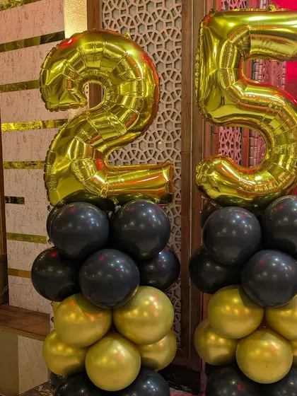 A close-up of the balloon pillars topped with large '25' foil numbers, a popular choice for milestone anniversary decorations.