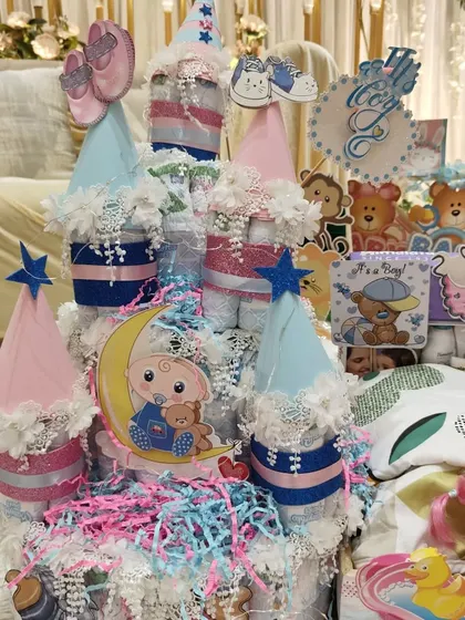 An adorable diaper cake at a baby shower. The "He or She" theme adds to the excitement and anticipation.
