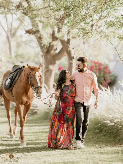 A couple walks hand-in-hand with a horse through a sun-drenched field. This creates a beautiful, rustic, and romantic narrative for their pre-wedding story.