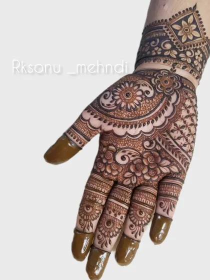 An intricate and full-coverage design perfect for a festive occasion. The pattern combines floral mandalas with detailed work on the fingers and a geometric wristband.