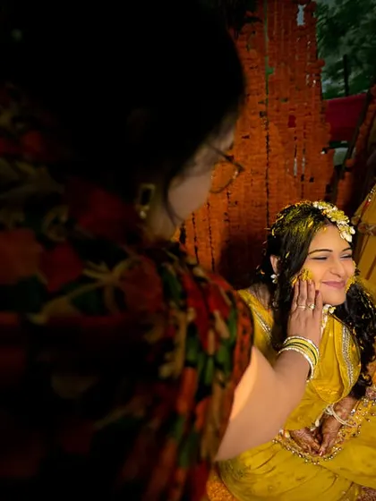 A mother's love. A tender moment as the mother applies haldi to her daughter, a beautiful and emotional candid shot.