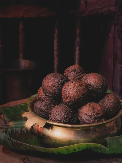 A dark and moody shot of Unniyappam, a traditional Kerala sweet, evoking nostalgia and the authentic flavors of Onam.