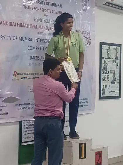Tannista Dineshkumar on the winner's podium, receiving her gold medal for the 10m Air Pistol event at the Inter Zonal Mumbai University Shooting Championship.