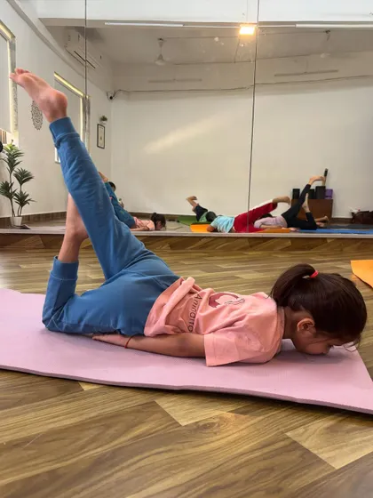 This young yogini is deeply focused while practicing a variation of the locust pose, building back strength and flexibility.