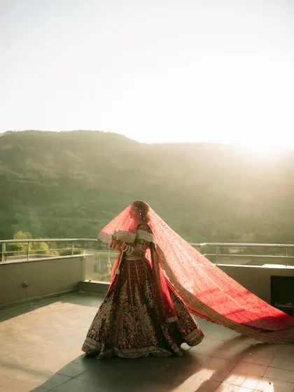 The bride holds her veil against the setting sun, creating a dramatic silhouette and a breathtaking fine-art portrait.