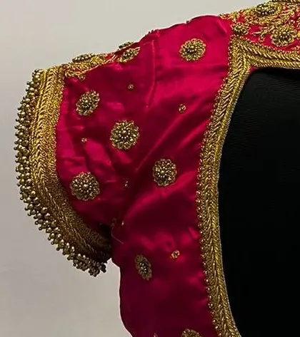 A close-up of the sleeve of the pink blouse, showing the detailed gold zardosi work and beaded border.