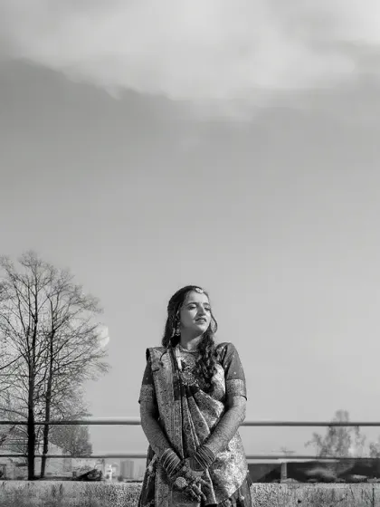 A wide, black and white shot of the bride against an open sky. This creates a feeling of serenity and timelessness, focusing on her solitary beauty.