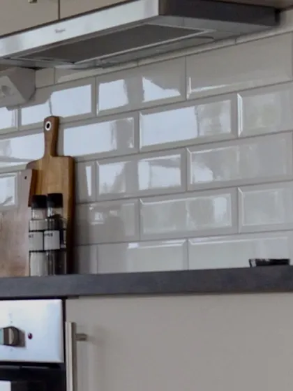 A detail shot of a glossy subway tile backsplash. This is a popular and practical choice as it's easy to clean and reflects light, making the kitchen feel brighter.