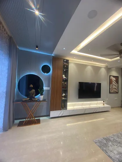 A close-up of the TV and console area, featuring a Buddha statue and unique circular mirrors with backlighting. These details create a serene and visually interesting focal point.